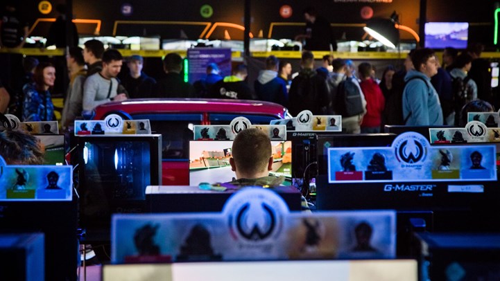 Stanowiska gamingowe i zwiedzający w strefie gier Poznań Game Arena